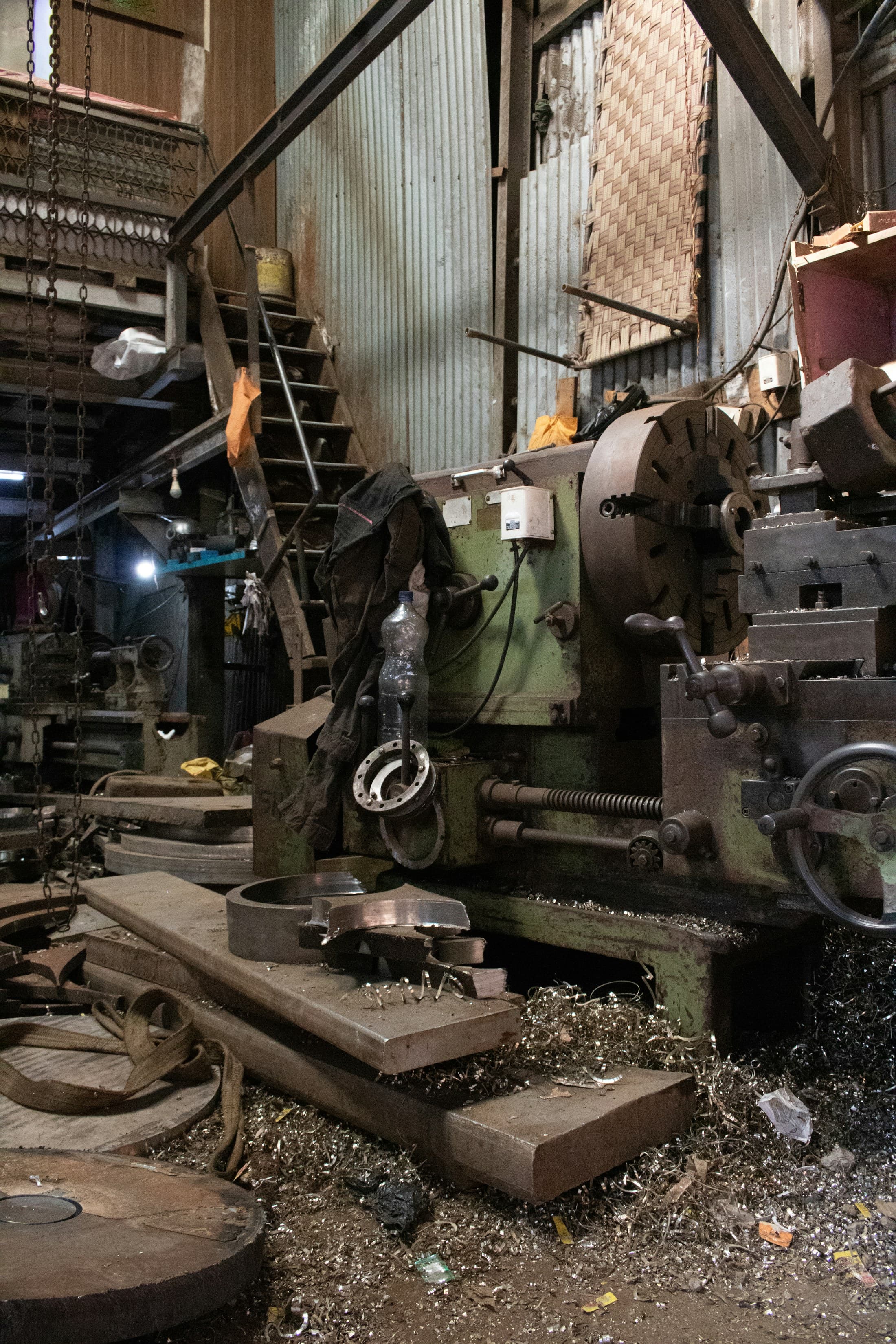 Large industrial lathe machining work in an Indian workshop